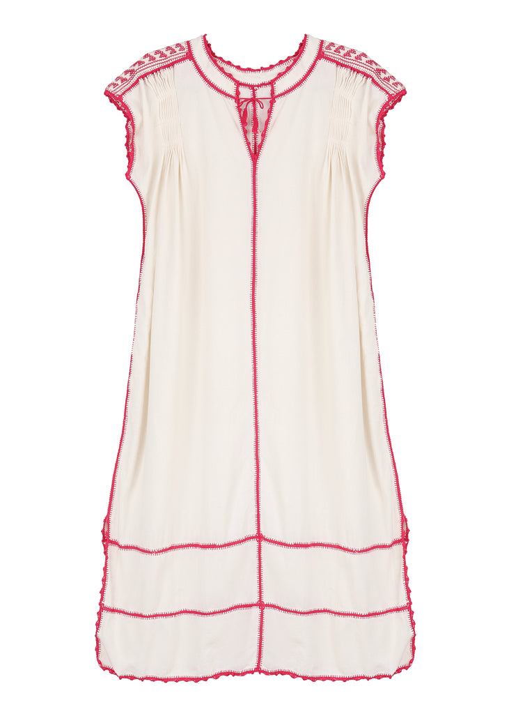 A short-sleeved white and pink dress with hand-crocheted details and a pleated design, featuring Mayan and Mixtec influences.