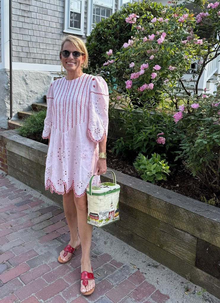 Woman in a pink dress with red and white embroidery on nantucket street
